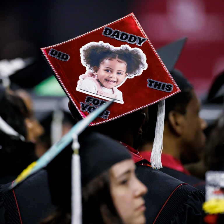 A decorated grad cap with a picture of a little girl and the words daddy did this for you!